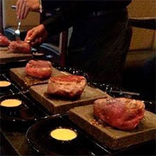 Steaks being served on 755-degree volcanic stone